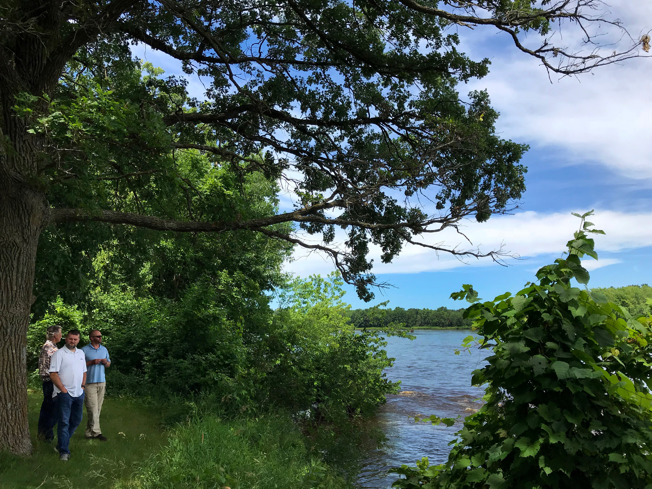 Staff visit Mississippi River shoreline during a tour of Camp Ripley.